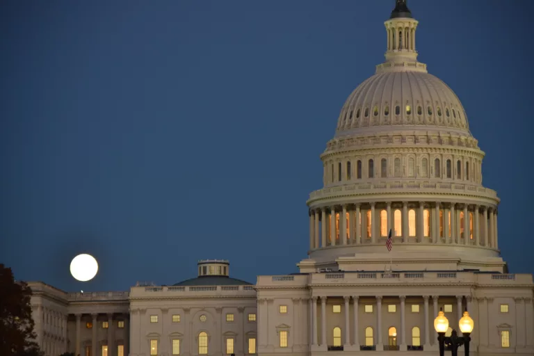 The us capital building at night with a full moon politics. Senate House of Representatives