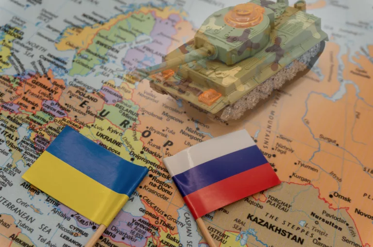 Ukrainische und russische Flaggen auf einer Europakarte, mit Panzer